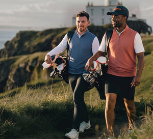 Models wearing Lightweight Sleeveless Quarter Zip Golf Vest while walking with golf bags on the course