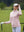 The model is wearing Women's Water-Resistant Stretch Fleece Lined Jacket light purple on the golf course.