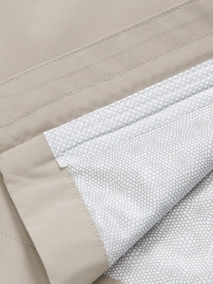 Close-up texture of khaki grey waterproof lightweight rain jacket with hood fabric showing water-repellent weave detail.