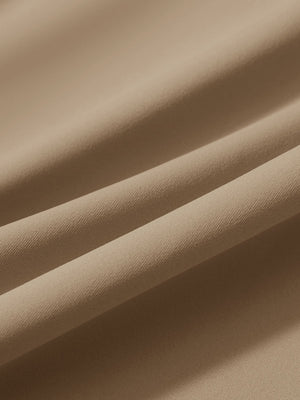 Close-up texture of light khaki women's lightweight athletic sweatpants fabric showing weave detail.