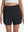 Front lower body shot of model wearing black women's gym golf shorts with liner pocket