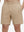 Front lower body shot of model wearing light khaki 4 way stretch breathable workout athletic shorts