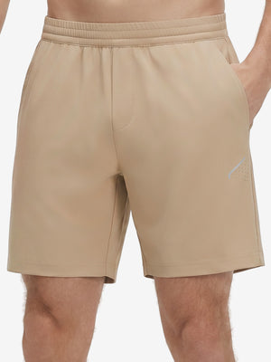 Front lower body shot of model wearing light khaki 4 way stretch breathable workout athletic shorts