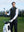 Model placing a golf club into a golf bag on course, styled in print collar quarter zip golf vest with dark grey