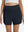 Front lower body shot of model wearing navy blue women's gym golf shorts with liner pocket