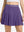 Front lower body shot of model wearing dark purple women's moisture-wicking athletic tennis skirts