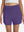 Front lower body shot of model wearing dark purple women's gym golf shorts with liner pocket
