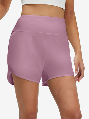 Front lower body shot of model wearing lavender pink women's high waist 2 in 1 quick dry shorts with 7 pockets