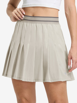 Front lower body shot of model wearing oyster gray women's moisture-wicking athletic tennis skirts
