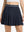 Front lower body shot of model wearing navy blue women's moisture-wicking athletic tennis skirts