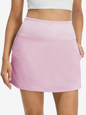 Front lower body shot of model wearing light pink women's stretch a-line golf skort with 7 pockets