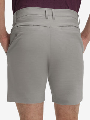Back lower body shot of model wearing light gray flat front hybrid golf shorts