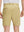 Back lower body shot of model wearing khaki flat front flex cotton blend golf shorts