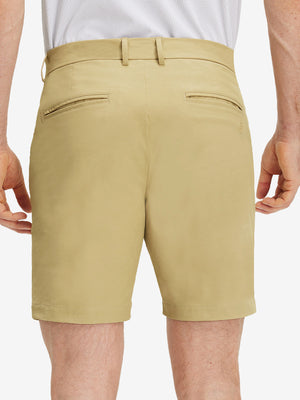 Back lower body shot of model wearing khaki flat front flex cotton blend golf shorts