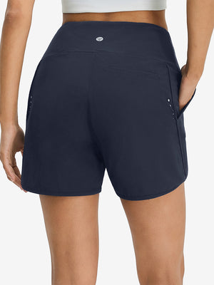 Back lower body shot of model wearing navy women's high waist 2 in 1 quick dry shorts with 7 pockets