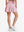 Back lower body shot of model wearing lavender women's high waisted golf skirts with 4 inner pockets