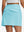 Back lower body shot of model wearing lake green women's stretch a-line golf skort with 7 pockets