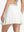 Back lower body shot of model wearing white women's moisture-wicking athletic tennis skirts