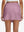Back lower body shot of model wearing lavender pink high waist built-in short a-line golf skirt with 5 pockets