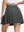 Back lower body shot of model wearing dark grey women's moisture-wicking athletic tennis skirts