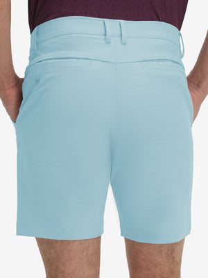 Back lower body shot of model wearing light blue flat front hybrid golf shorts