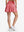 Back lower body shot of model wearing pink women's high waisted golf skirts with 4 inner pockets