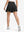 Back lower body shot of model wearing black women's high waisted golf skirts with 4 inner pockets
