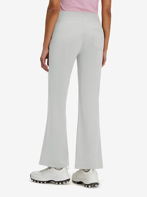 Back lower body shot of model wearing silver gray women's high waist stretch golf pants with pockets