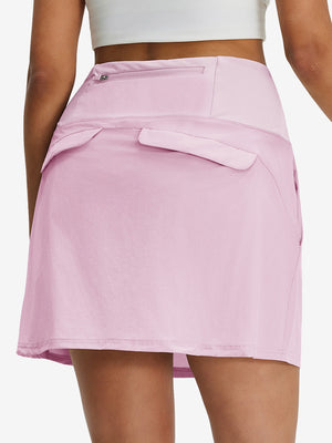 Back lower body shot of model wearing light pink women's stretch a-line golf skort with 7 pockets