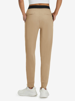 Back lower body shot of model wearing light khaki women's lightweight athletic sweatpants
