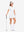 Front full body with golf club in white of women's lightweight golf dress with 2 pockets.