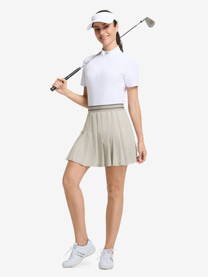 Front full body shot of model with golf gear wearing oyster gray women's moisture-wicking athletic tennis skirts