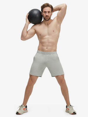 Front full body shot of model exercising in silver gray 4 way stretch breathable workout athletic shorts