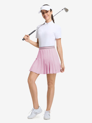 Front full body shot of model with golf gear wearing light pink women's moisture-wicking athletic tennis skirts
