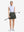 Front full body shot of model with golf gear wearing army green women's moisture-wicking athletic tennis skirts