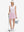Front full body shot of model with golf gear wearing light pink women's stretch a-line golf skort with 7 pockets