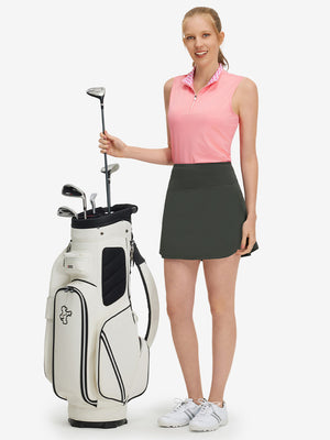 Front full body shot of model with golf gear wearing dark grey women's stretch a-line golf skort with 7 pockets