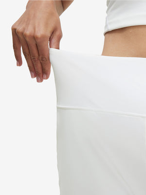 Detail view of elastic waistband on white women's high waist 2 in 1 quick dry shorts with 7 pockets