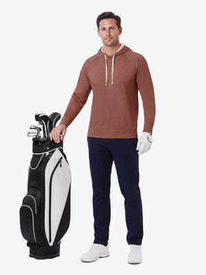 Full body model holding golf gear outdoors, heather midlayer golf hoodies in red ochre heather