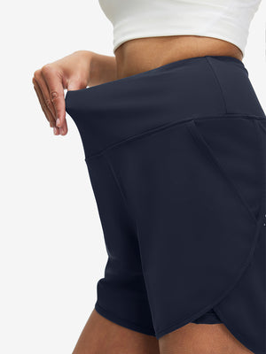 Detail view of elastic waistband on navy women's high waist 2 in 1 quick dry shorts with 7 pockets