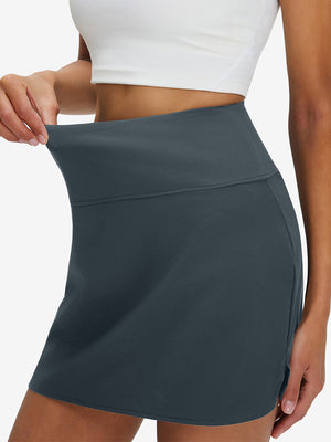 Detail view of elastic waistband on dark grey high waist built-in short a-line golf skirt with 5 pockets