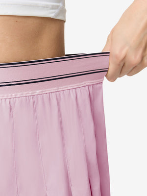 Detail view of elastic waistband on light pink women's moisture-wicking athletic tennis skirts