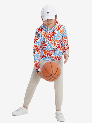 A full-body shot of a model wearing a youth full print stylish hoodie pullover in colorful flower, playing basketball