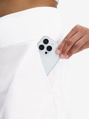 Detail view of back pocket on white women's stretch a-line golf skort with 7 pockets