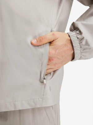 Detail view of outer pocket on khaki grey waterproof lightweight rain jacket with hood