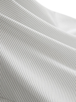 Close-up texture of light grey white women's q-zip pin striped texture golf shirts fabric showing pin striped weave detail.