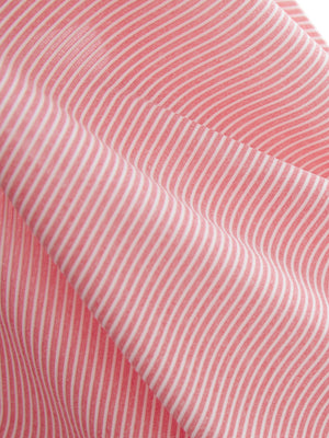Close-up texture of pink coral white women's q-zip pin striped texture golf shirts fabric showing pin striped weave detail.