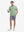 Full-body view of model holding takeaway drink cup in light green cotton blend plain shirt.