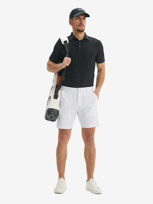 Front full body shot of model wearing rich black grid performance reflective checked collar golf shirt