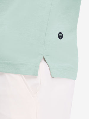 Hem detail close-up in light green heather of performance heather contrast collar polo shirts.